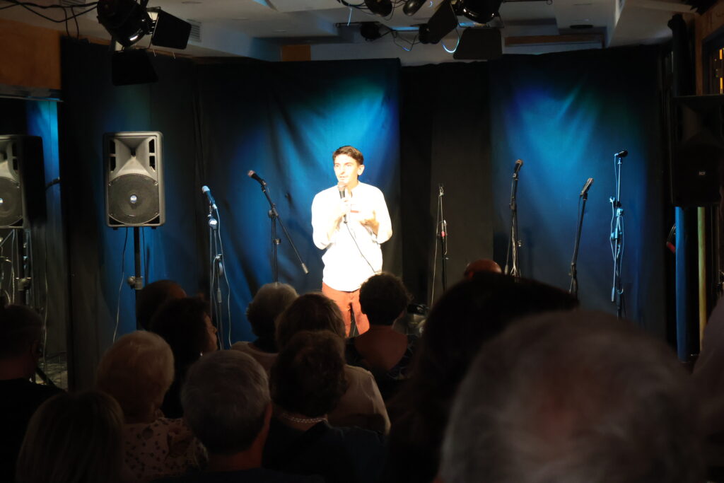 Manuele Guarnacci davanti al pubblico durante un monologo teatrale di presentazione dei corsi e laboratori nella sala prove grande al Quindilab.
